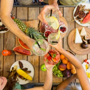 Friends clinking glasses above outdoor table