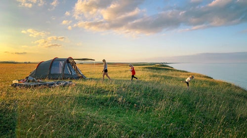 Family camping near large body of water