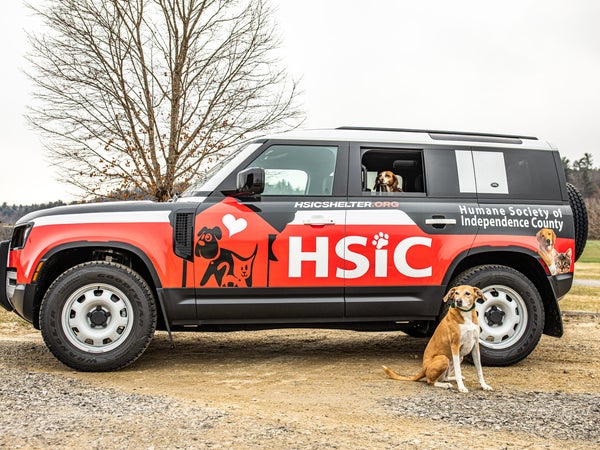 The Humane Society of Independence County, Arkansas, uses the Land Rover Defender it won in the 2021 Defender Service Awards to rescue animals, like the dogs in and in front of the Defender.