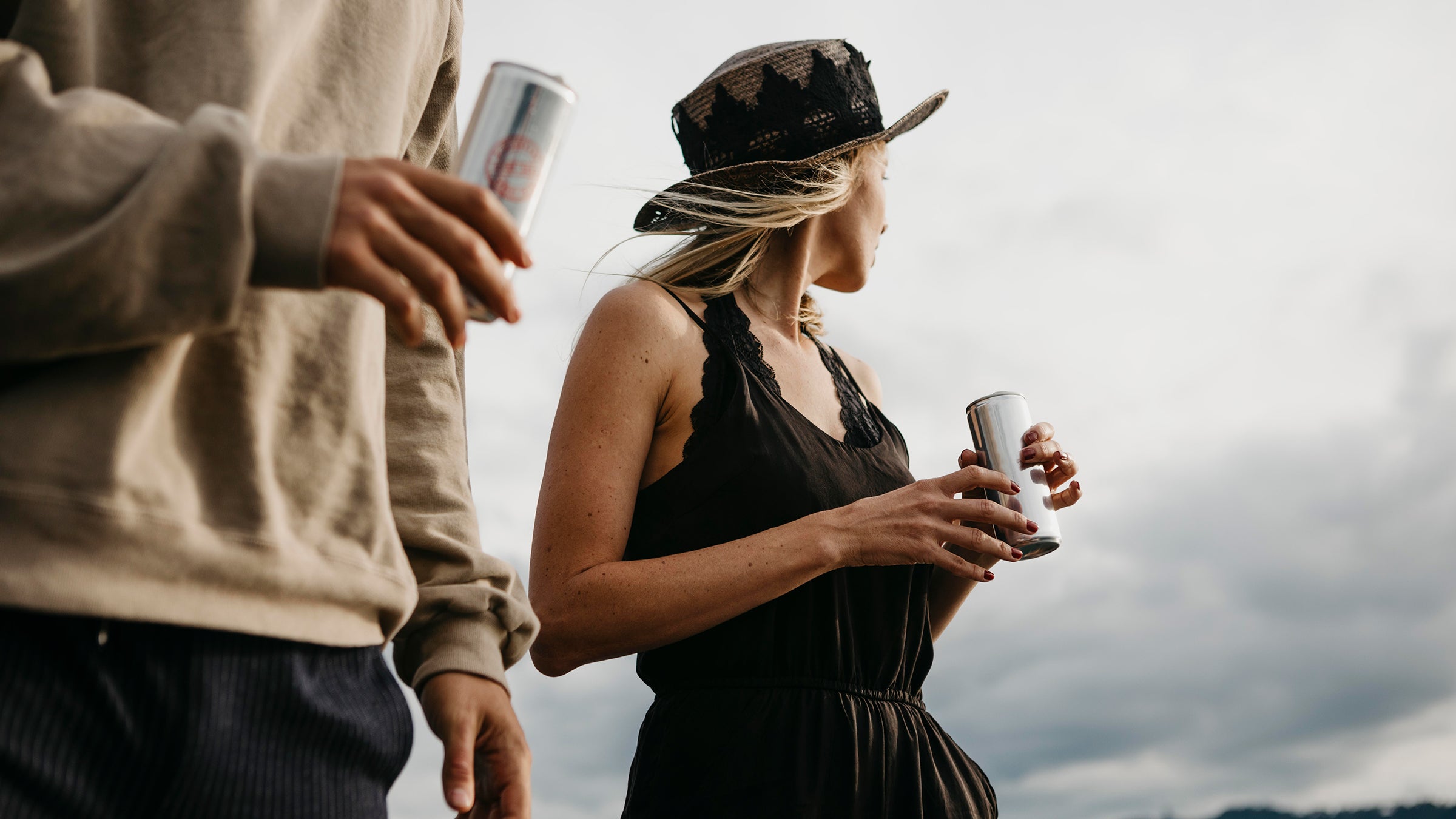 Two people having a canned drink outdoors