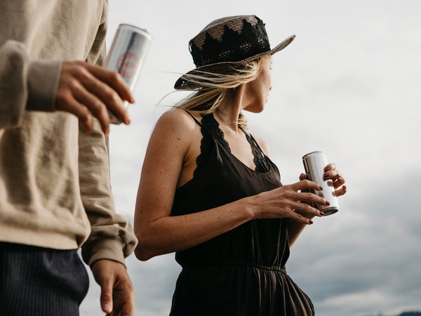 Two people having a canned drink outdoors