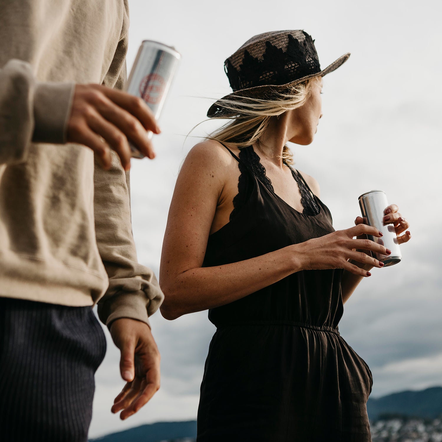 Two people having a canned drink outdoors