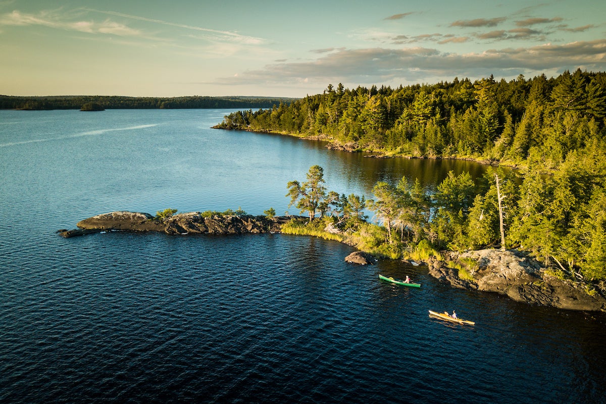 Sea kayakers paddle near the shore in northern Maine.