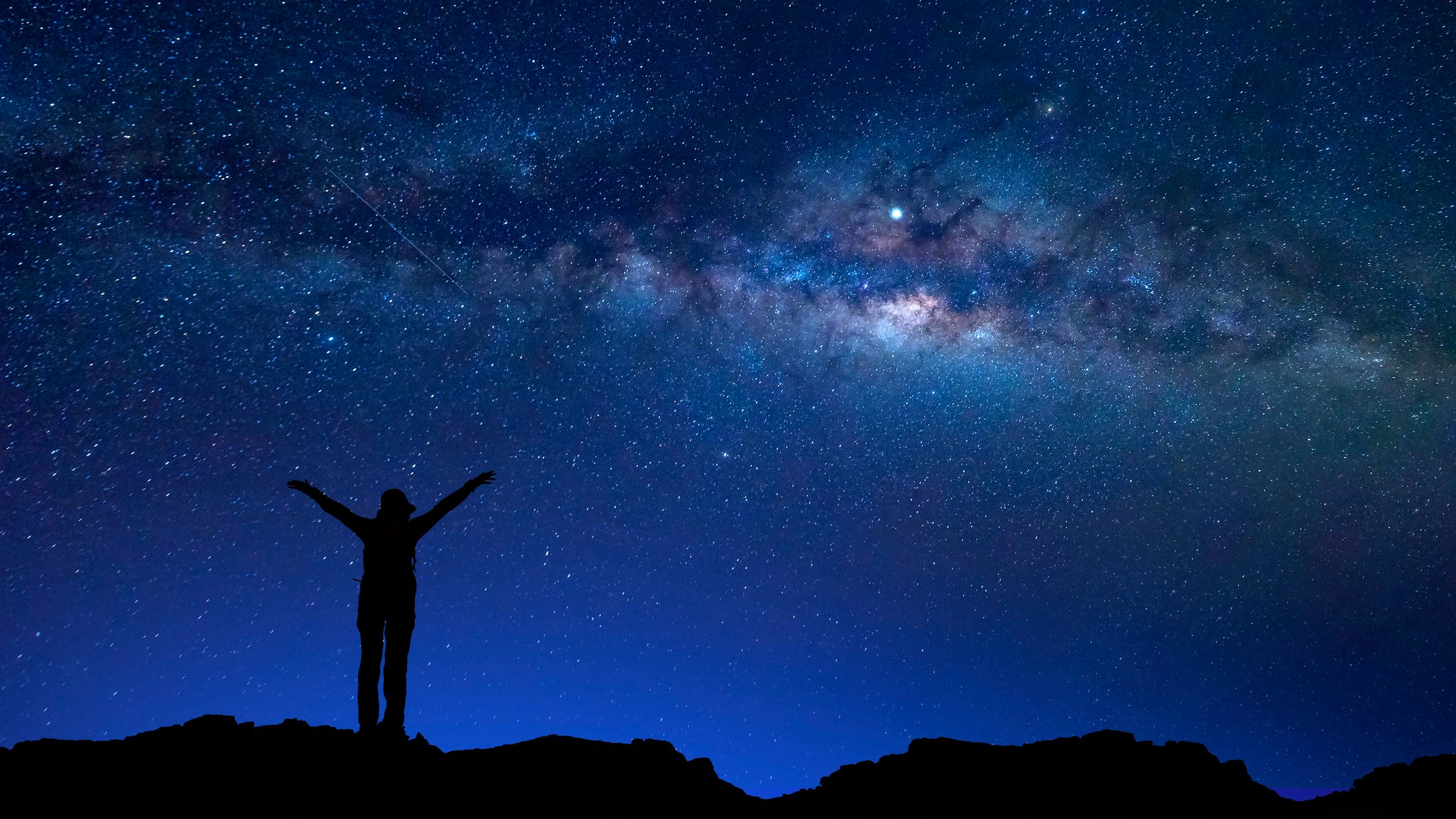 A hiker stares at the stars.