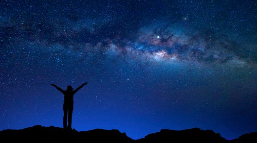 A hiker stares at the stars.