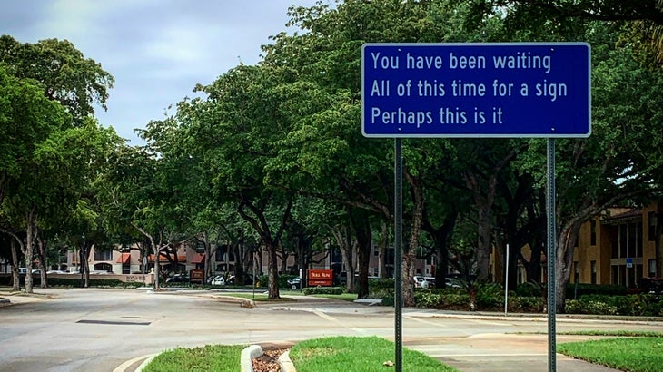 A sign next to a street