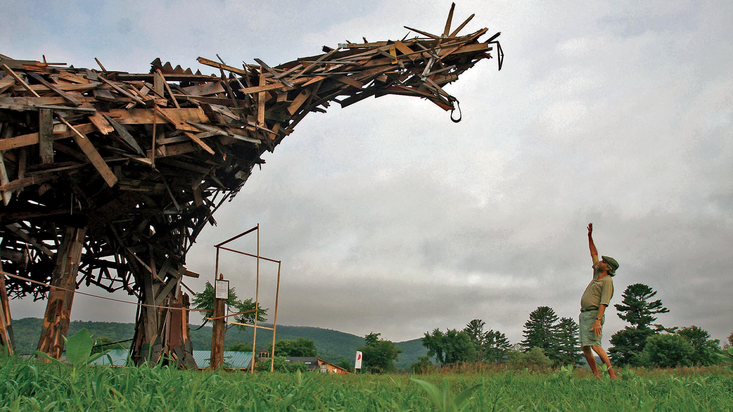 Boland standing in front of his 25-foot-tall Vermontasaurus sculpture in 2010