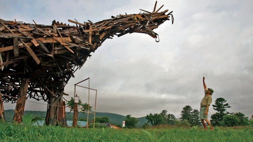 Boland standing in front of his 25-foot-tall Vermontasaurus sculpture in 2010