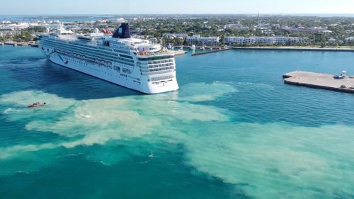 The Norwegian Dawn kicks up silt heading into a Key West port.