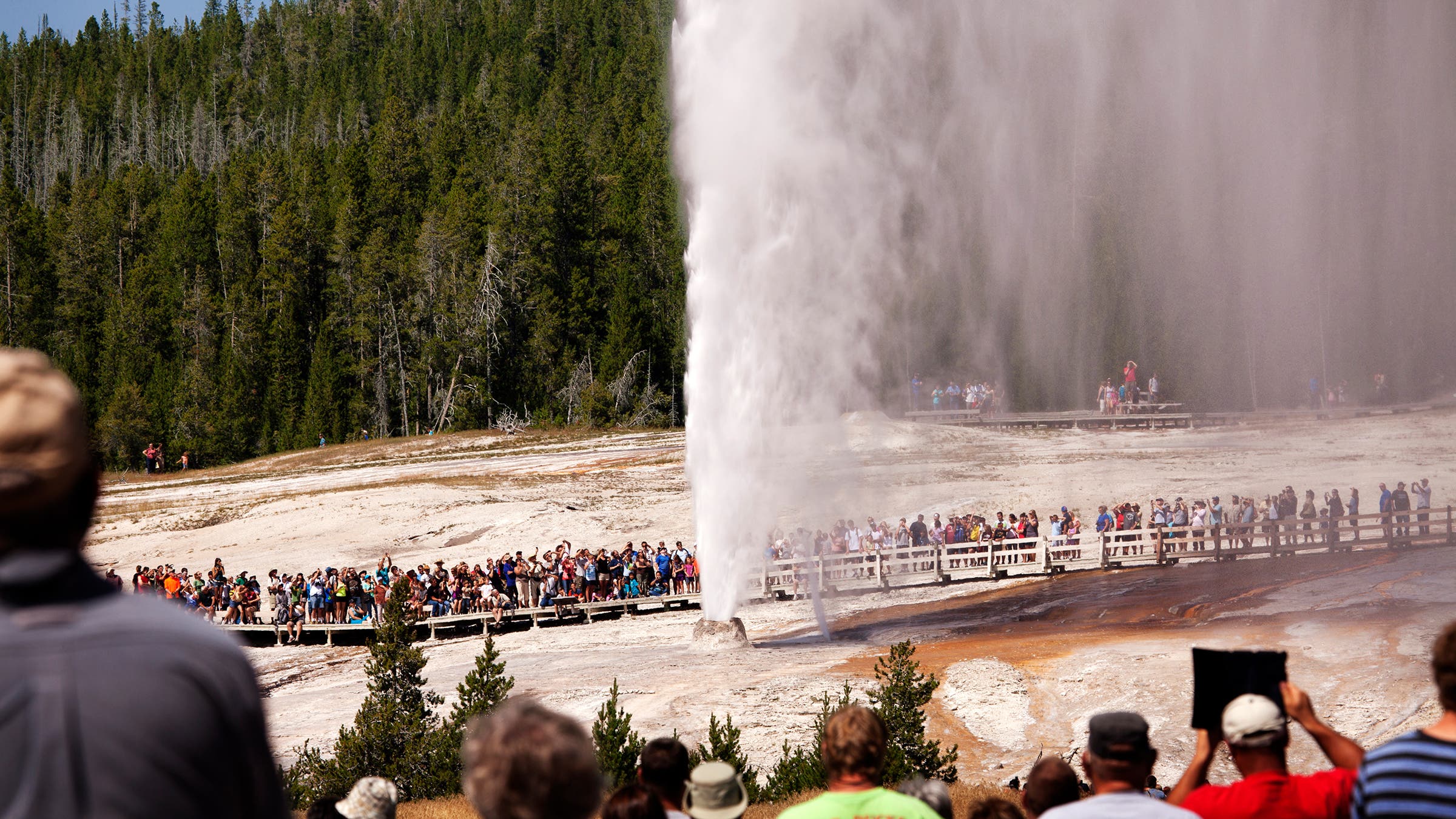 Tourists visiting Old Faithful Geyser at Yellowstone National Park