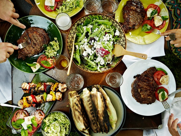 Overhead view of friends dining at table with food in backyard garden