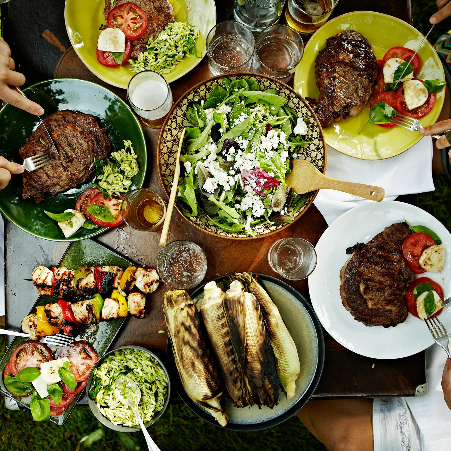 Overhead view of friends dining at table with food in backyard garden