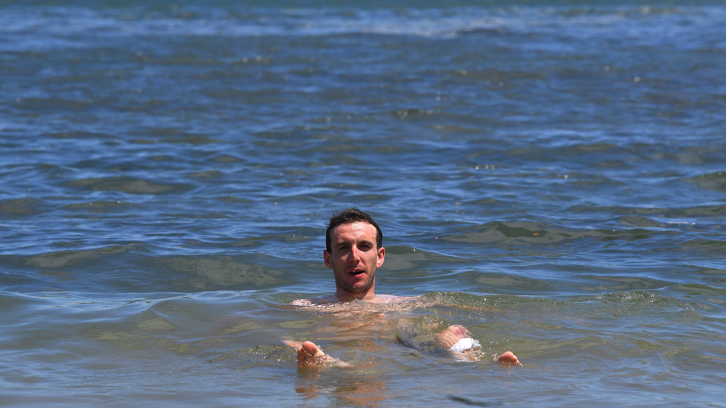 Simon Yates swimming in the ocean at the Tour Down Under