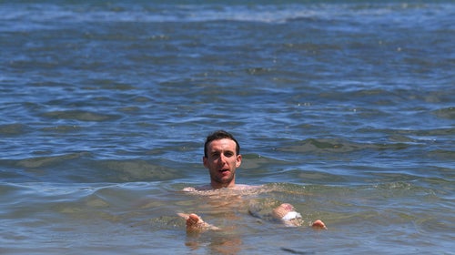 Simon Yates swimming in the ocean at the Tour Down Under