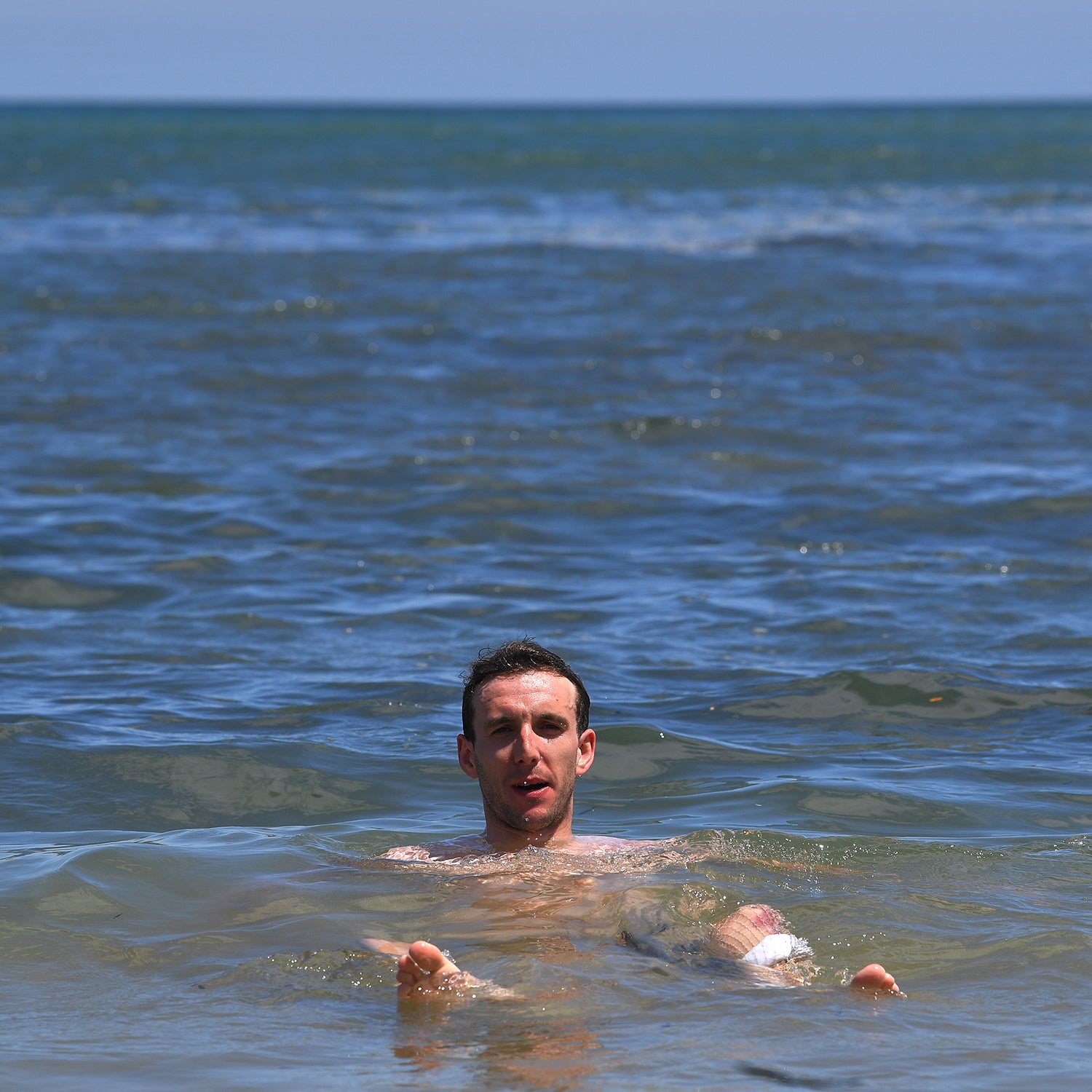 Simon Yates swimming in the ocean at the Tour Down Under