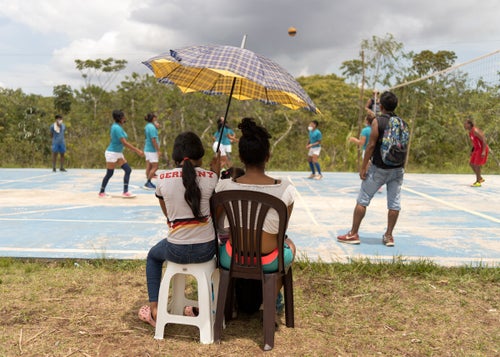Under the hot sun, neighborhood girls watch a Wigudun Galu match.