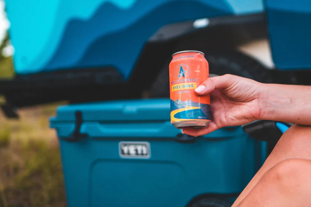Athletic Brewing Company's Freeride Hazy IPA in front of a Yeti Cooler