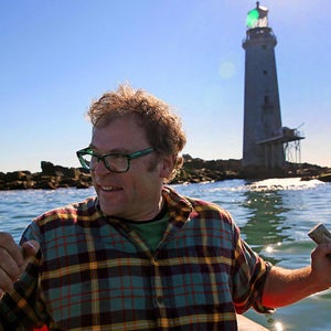 man rowboat lighthouse