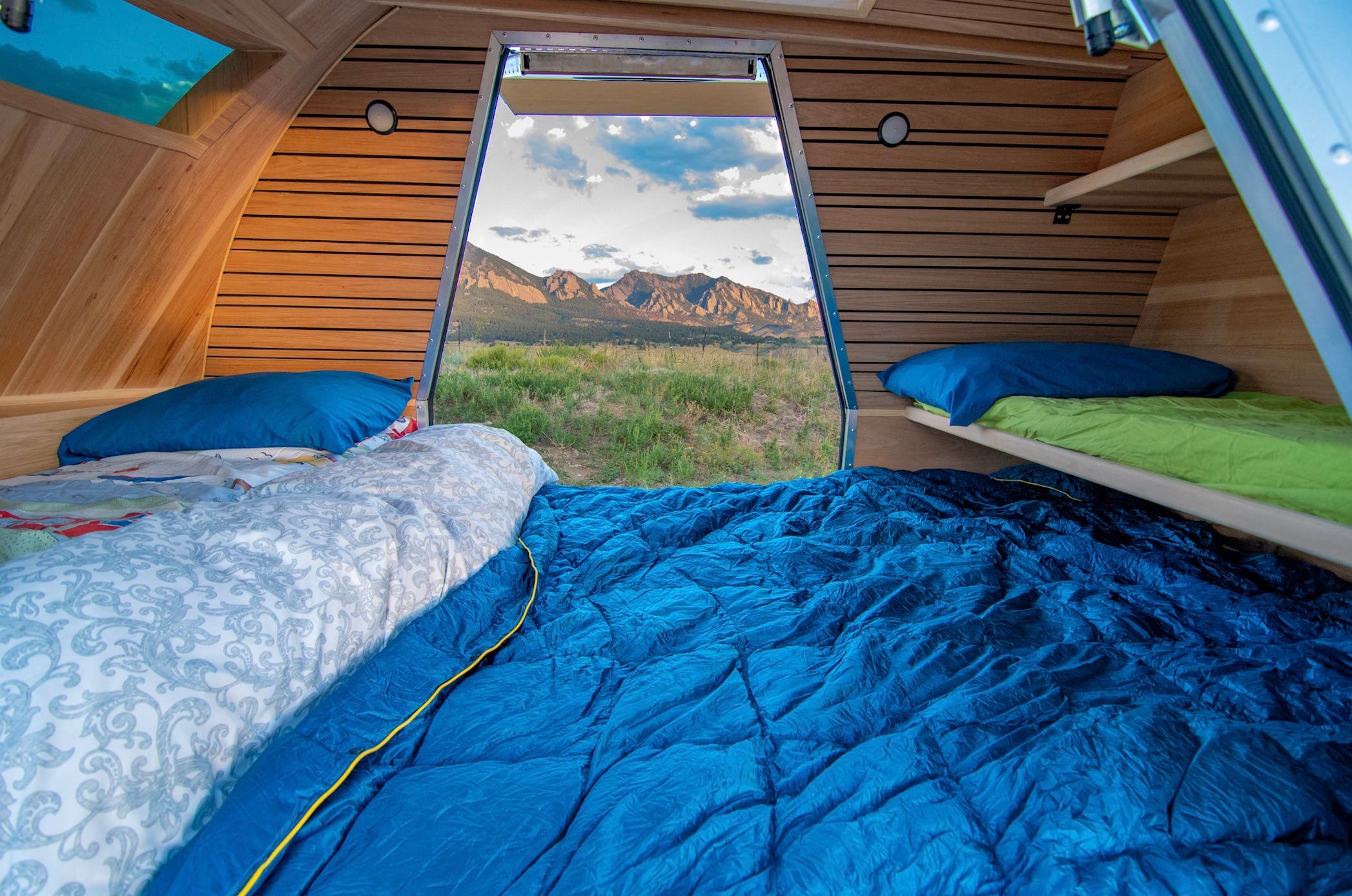 Bed set up inside a small camping trailer