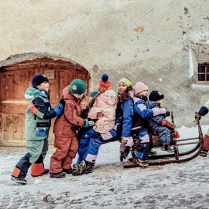 Kids in outdoor gear pulling a sled