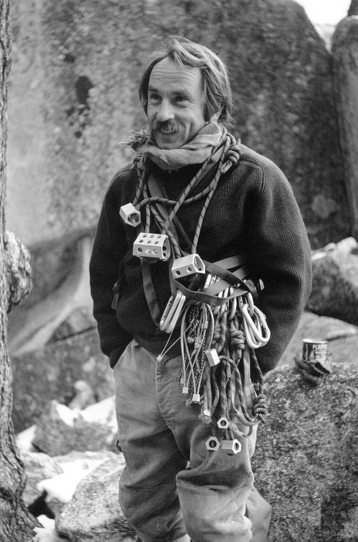 Black-and-white photo of a young man with rock climbing equipment