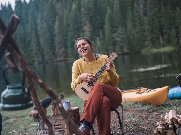 woman strumming a guitar during a campfire skit