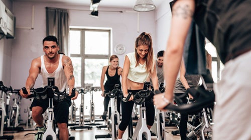 People work out on bikes in an indoor spin class