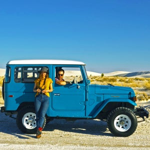 Two travelers with a land cruiser in the desert