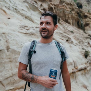 Man holding a drink from Athletic Brewing Company