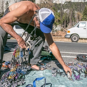 A shirtless climber sorts gear prior to a climb of El Capitan