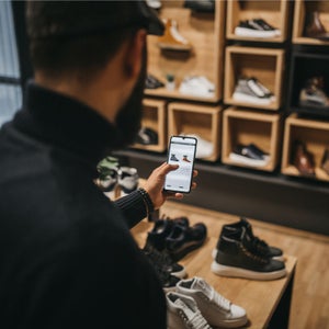 Customer online shopping while in shoe store