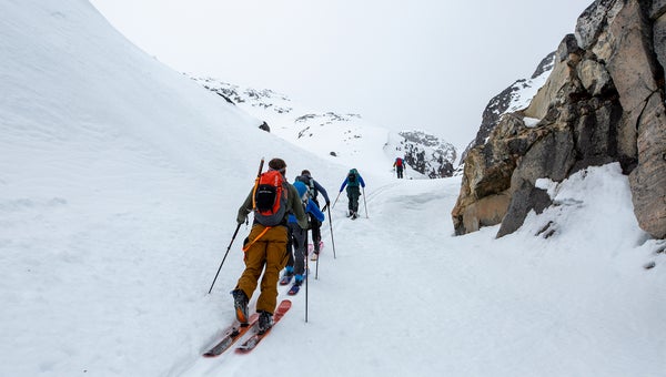 Skiers touring with packs of gear