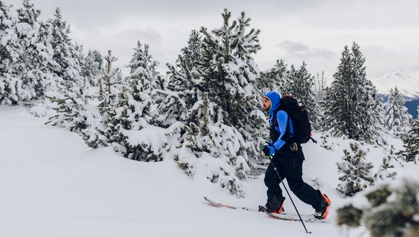 Young man moving up the snowy mountain in the best splitboard gear