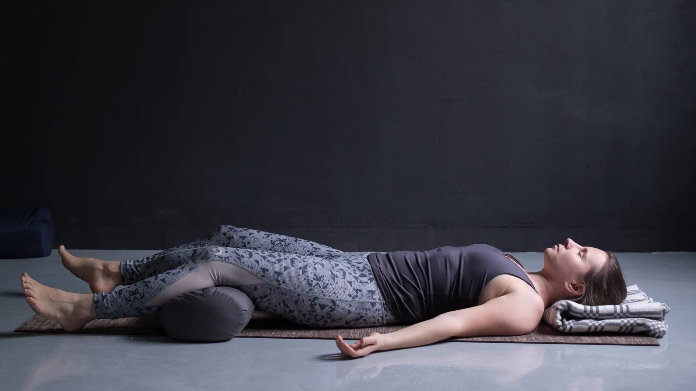 Woman lying on her back in Savasana to help her sleep better