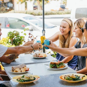 A group of friends cheers drinks from Athletic Brewing Company