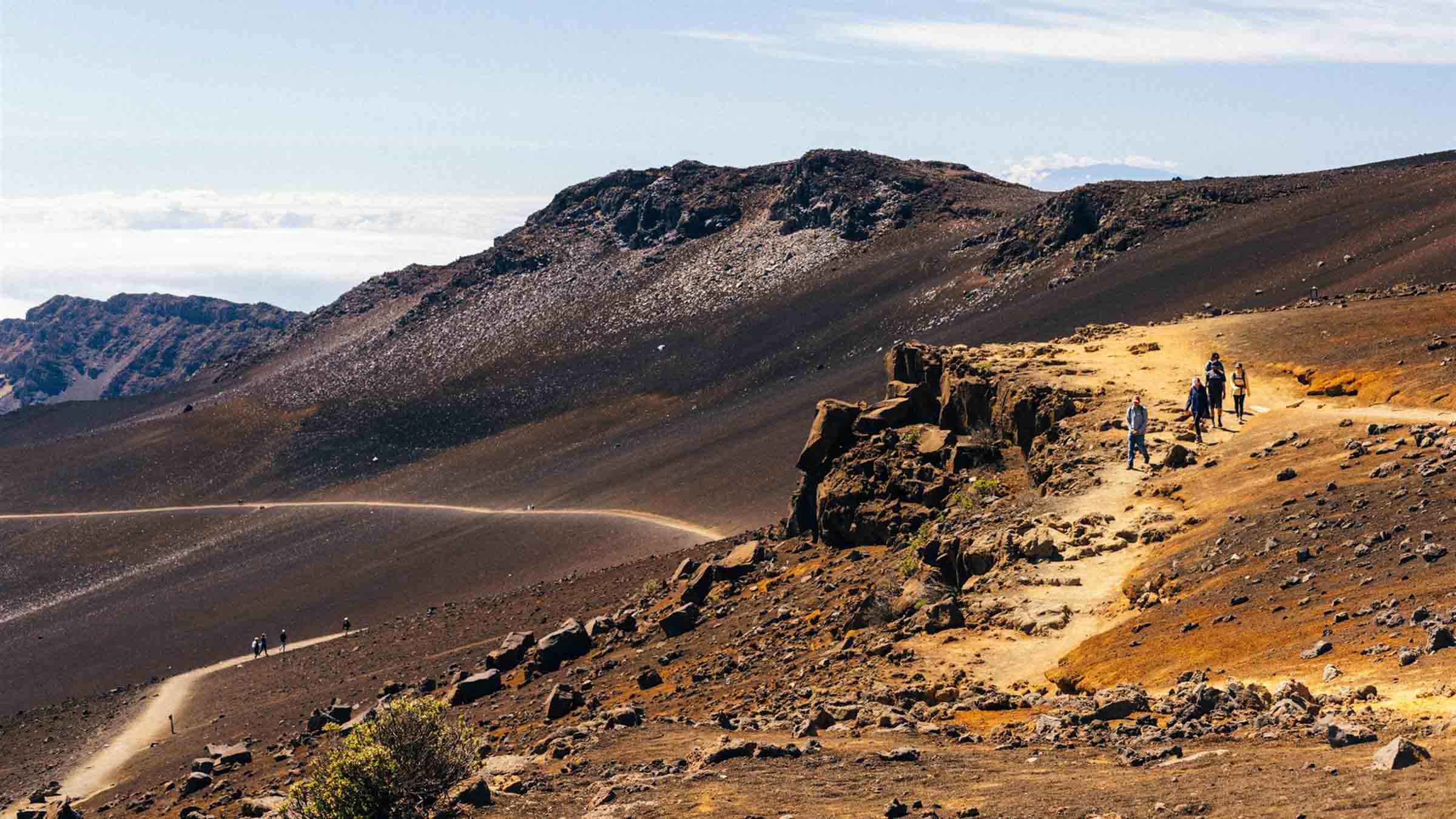 Hikers make their way along the desolate path of Sliding Sands, the classic trek on Haleakala, Maui