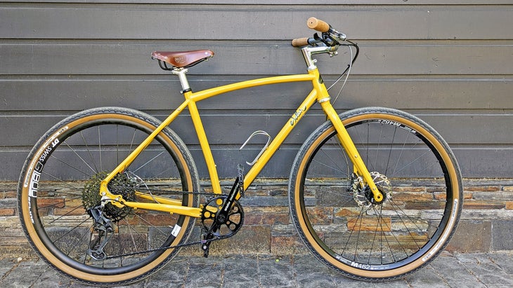 a commuter bike in yellow propped up against a house