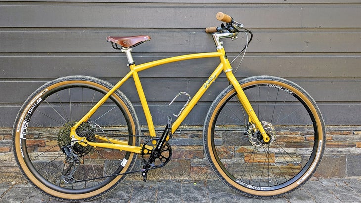 a commuter bike in yellow propped up against a house