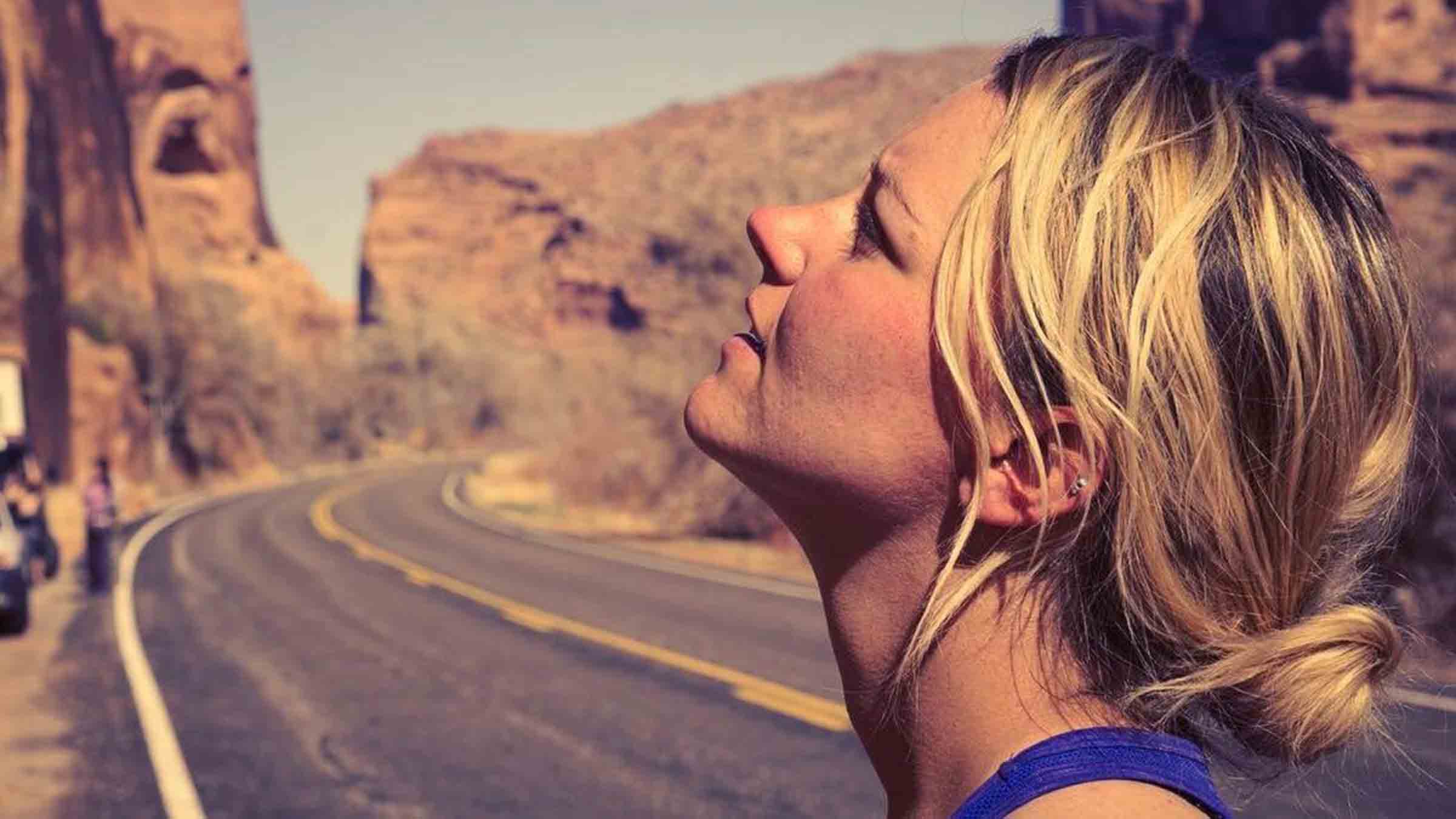 woman looking up at cliffs