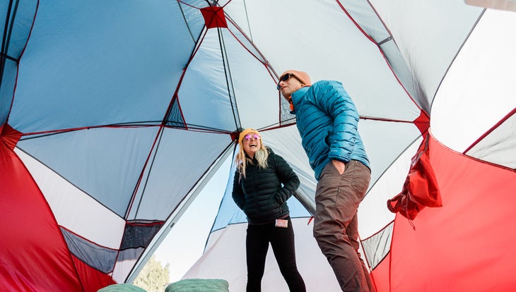 two people standing inside a big tent
