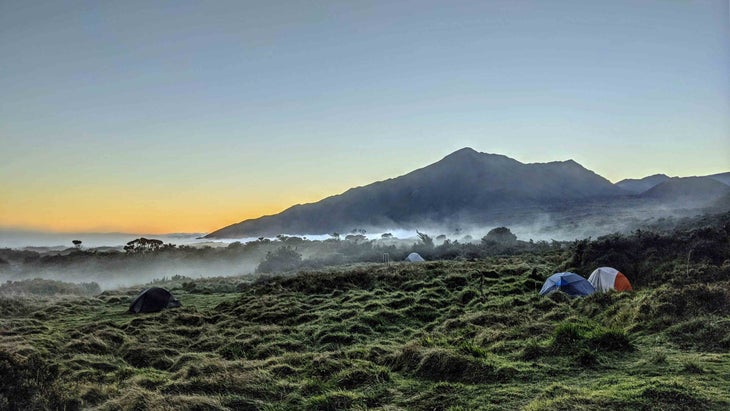 Two tents pitched amid the mist coming up Maui’s Kaupo Gap before the sun sets behind Haleakala.