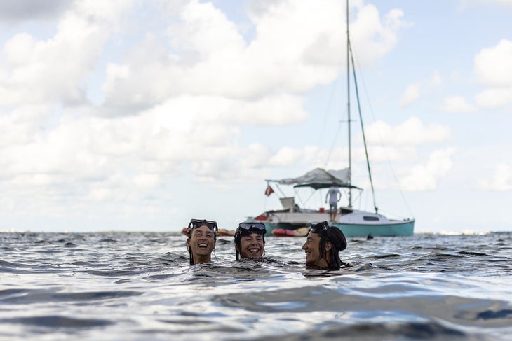 three people swimming in the ocean