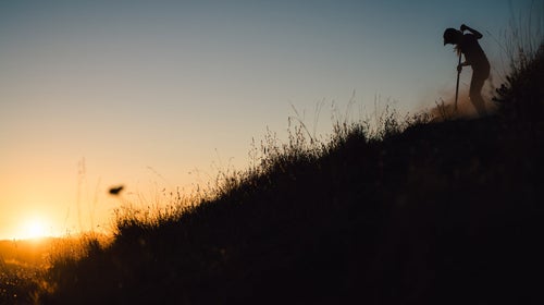 Silhouette of person digging trail