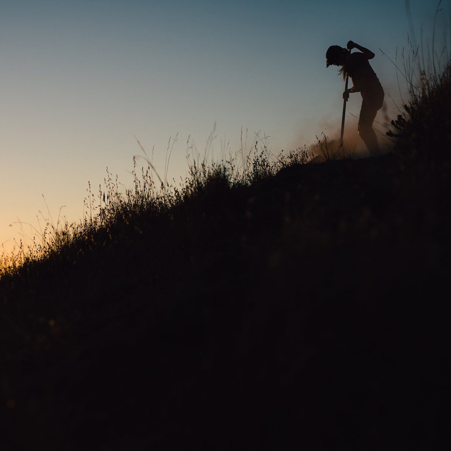 Silhouette of person digging trail