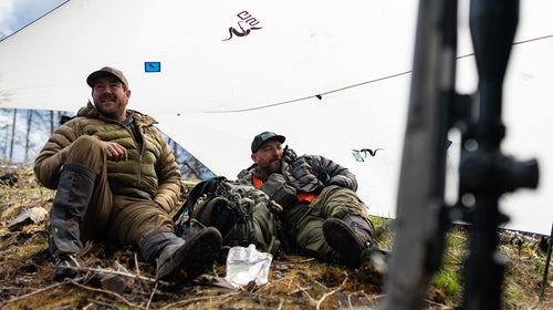 hunters resting under a tarp lean-to