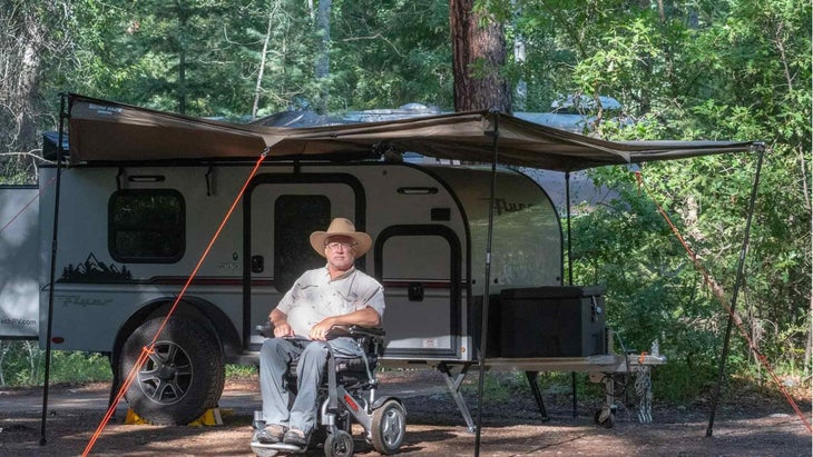 man in wheelchair with camper