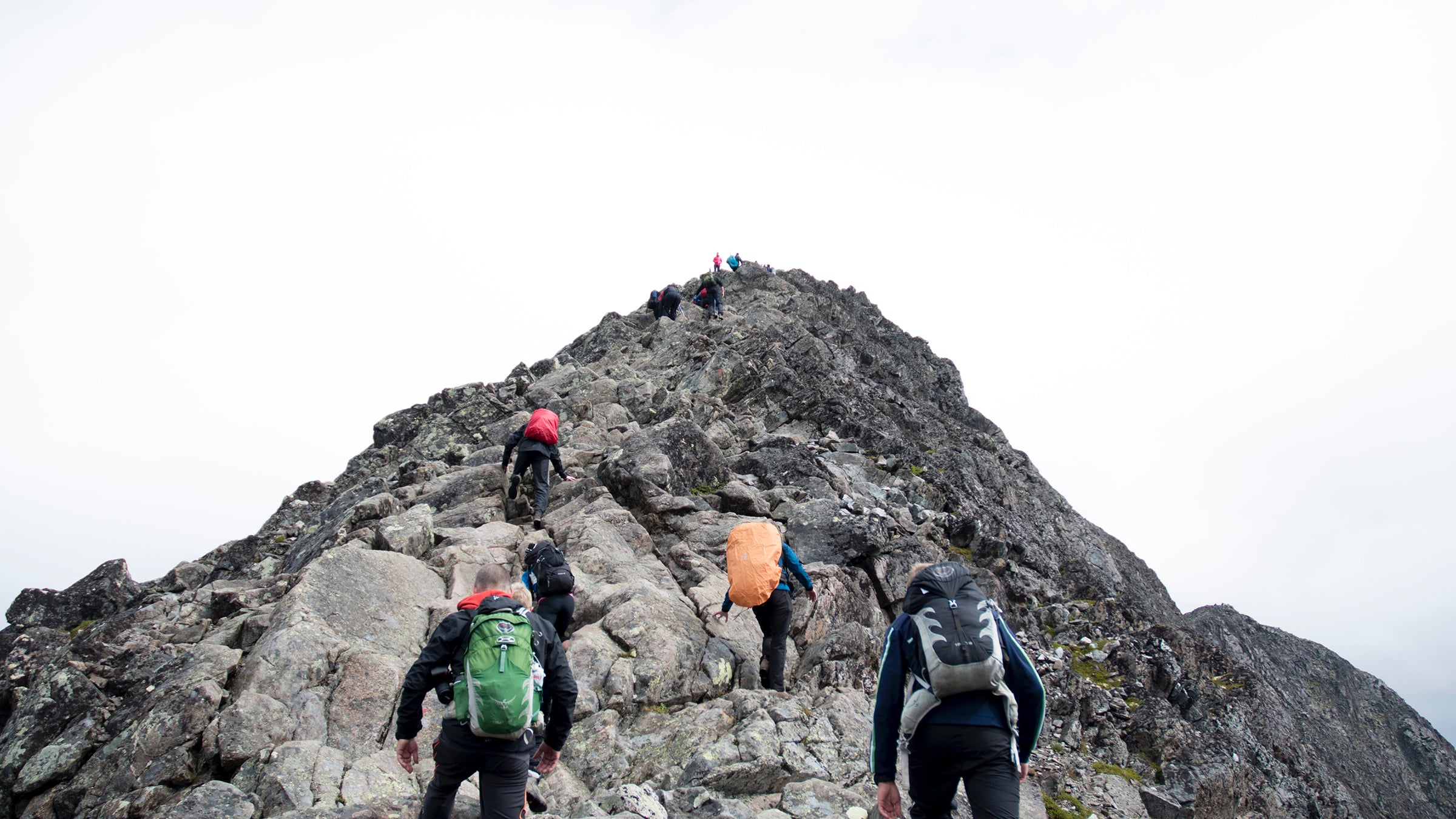 Climbers approaching the peak of a mountain