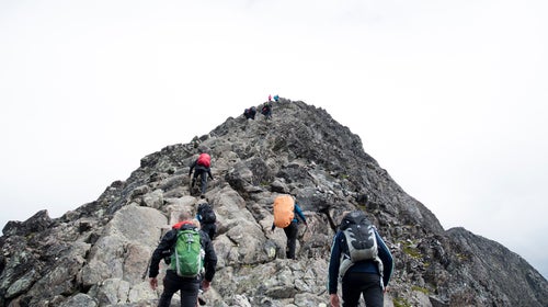 Climbers approaching the peak of a mountain