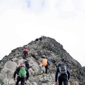 Climbers approaching the peak of a mountain