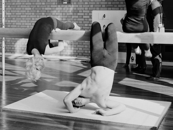 Vintage black and white photo of a gymnastics class using gym equipment